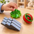 R$25 fidget toy assortment: green star spinner, red and green fidget ball, and silver segmented fidget toy in a children's play setting.